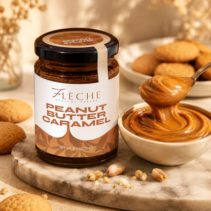 Jar of Fleche Peanut Butter Caramel with a spoonful of the spread on a marble surface.