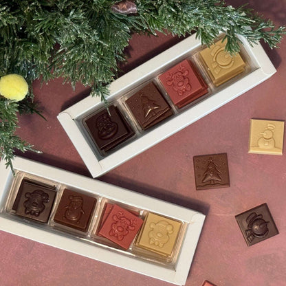 Flèche Healthy Treats assorted vegan chocolate collection with holiday-themed squares and festive packaging.